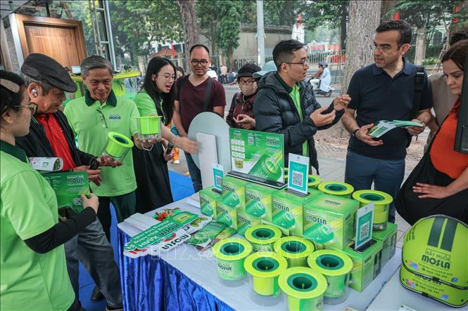 Khách hàng tìm hiểu, chọn mua sản phẩm bẫy muỗi Mosla. Ảnh: Hoàng Hiếu - TTXVN