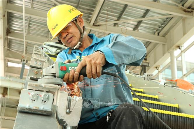 Người lao động hoàn thiện thang cuốn nhà ga hành khách sân bay Long Thành. Ảnh: Công Phong - TTXVN