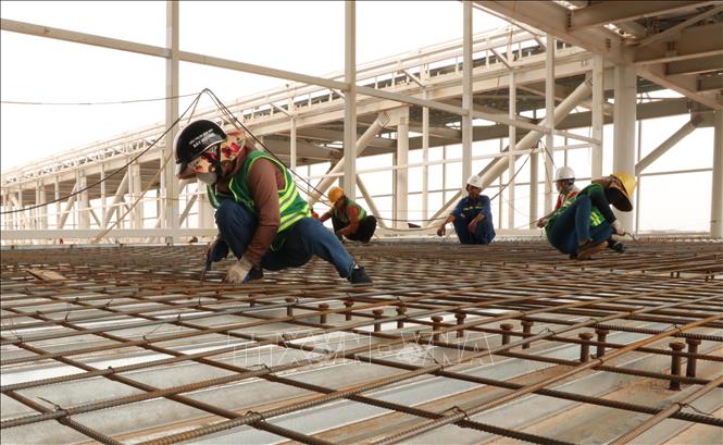 Người lao động hoàn thiện lưới thép tại cầu ống lồng nhà ga hành khách sân bay Long Thành. Ảnh: Công Phong - TTXVN