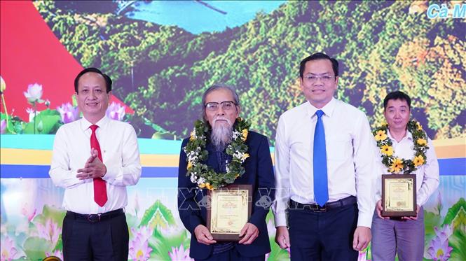 Chủ tịch HĐND tỉnh Cà Mau Phạm Văn Thiều (trái) và Phó Chủ tịch UBND tỉnh Cà Mau Ngô Vũ Thăng (phải) trao giải cho tác giả đạt giải thưởng văn học, nghệ thuật Phan Ngọc Hiển lần thứ V. Ảnh: Huỳnh Anh - TTXVN