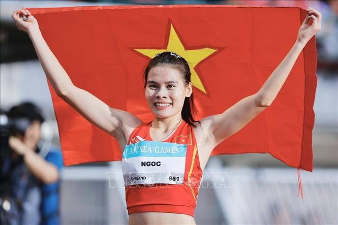 VĐV điền kinh Nguyễn Thị Ngọc với lá cờ Tổ quốc sau khi đạt thành tích 52,74 giây ở chung kết 400m nữ. Ảnh: Minh Quyết - PV TTXVN tại Thái Lan