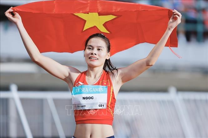 VĐV điền kinh Nguyễn Thị Ngọc với lá cờ Tổ quốc sau khi giành huy chương Vàng chạy 400m nữ tại SEA Games 33. Ảnh: Minh Quyết - PV TTXVN tại Thái Lan