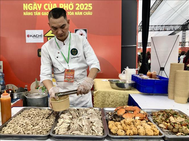 Đầu bếp chuyên nghiệp của thương hiệu phở nổi tiếng phục vụ phở tại chỗ. Ảnh: Mỹ Phương – TTXVN.