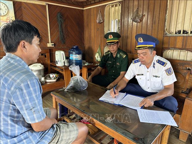 Lực lượng chức năng làm việc với thuyền trưởng phương tiện ĐN 1233 Trần Văn Thường. Ảnh: TTXVN phát 
