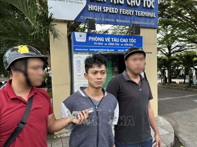 Các trinh sát áp giải đối tượng tàng trữ ma túy Nguyễn Xuân Mạnh (giữa). Ảnh: TTXVN phát 