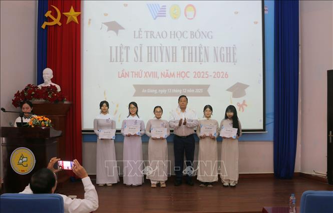 Ông Nguyễn Tấn Danh, nguyên Chủ tịch Hội Khuyến học tỉnh An Giang trao học bổng Liệt sĩ Huỳnh Thiện Nghệ cho các em học sinh Trường THPT Thực hành sư phạm - Đại học An Giang. Ảnh: Công Mạo-TTXVN 