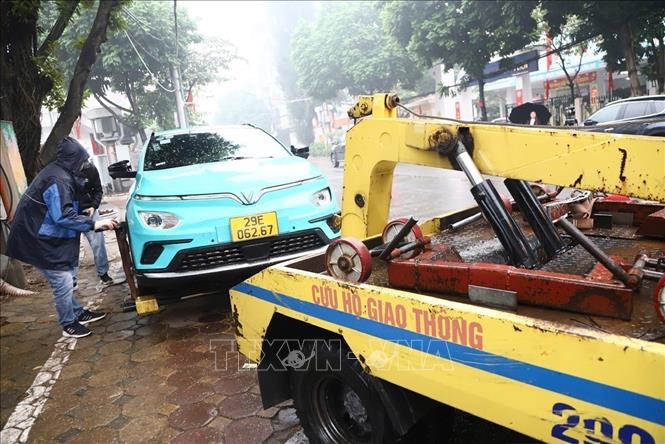 Lực lượng chức năng cẩu xe vi phạm tại phố Tứ Liên, phường Hồng Hà, thành phố Hà Nội. Ảnh: Quốc Lũy - TTXVN