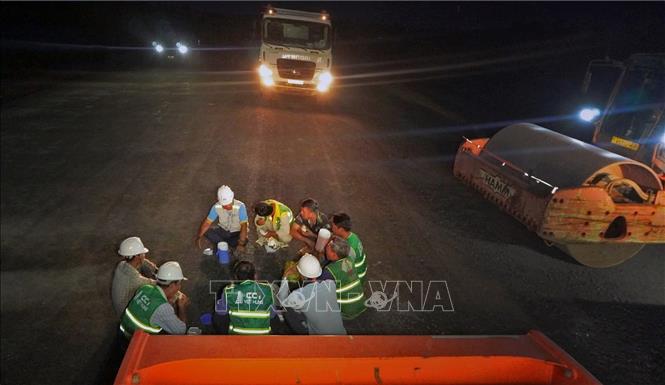 Cán bộ kỹ sư, công nhân tranh thủ ăn vội để quay trở lại làm việc. Ảnh: Huỳnh Anh - TTXVN