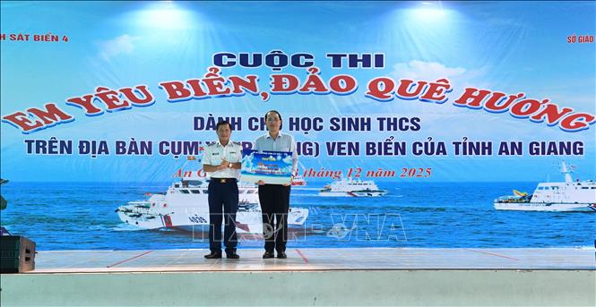 Đại diện Sở Giáo dục & Đào tạo tỉnh An Giang nhận biểu trưng 60 suất học bổng do Bộ Tư lệnh Vùng Cảnh sát biển 4 trao tặng. Ảnh: TTXVN phát