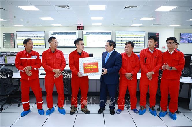 Thủ tướng Phạm Minh Chính tặng quà cho kỹ sư, chuyên gia điều hành Nhà máy điện LNG Nhơn Trạch 3 và 4. Ảnh: Dương Giang-TTXVN 
