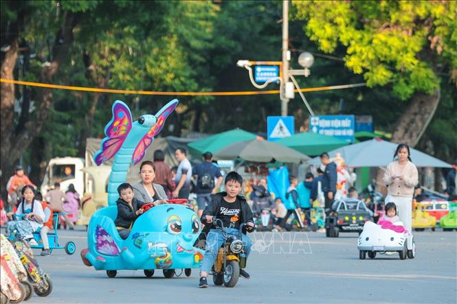Nhiều gia đình cho trẻ em tham gia các hoạt động trải nghiệm tại phố đi bộ Trần Nhân Tông chiều 14/12. Ảnh: Hoàng Hiếu - TTXVN