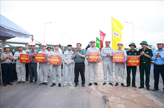 Thủ tướng Phạm Minh Chính tặng quà công nhân thi công nút giao với Sân bay Long Thành (Dự án thành phần 1 và Dự án thành phần 2 thuộc Dự án cao tốc Biên Hòa - Vũng Tàu). Ảnh: Dương Giang-TTXVN 
