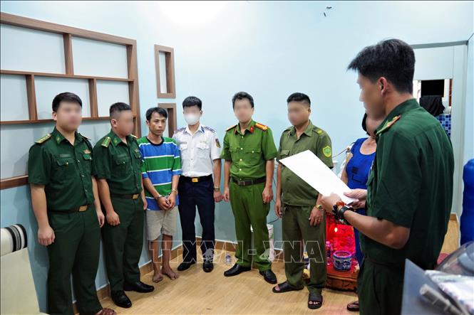 Lực lượng đánh án đọc lệnh bắt đối tượng Trần Trung Hiếu. Ảnh: TTXVN phát 