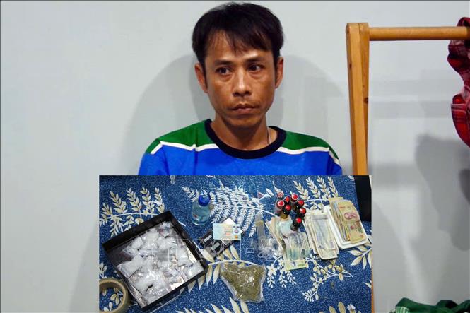 Đối tượng Trần Trung Hiếu và tang vật. Ảnh: TTXVN phát 