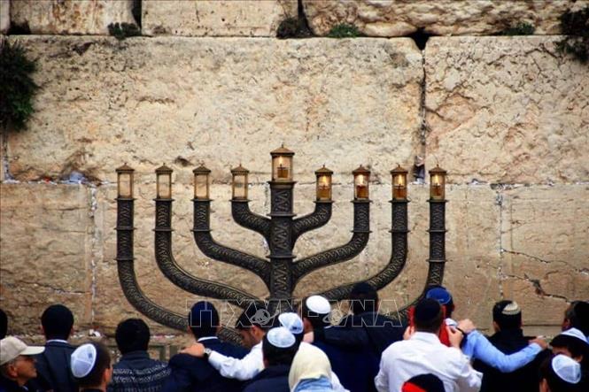Lễ hội Chanukah kỷ niệm chiến thắng của người Do Thái trước đế chế Seleucid cách đây hơn 2.000 năm, cùng phép màu bình dầu chỉ đủ thắp trong một ngày nhưng đã cháy suốt tám ngày tại Đền Thánh Jerusalem. Ảnh: TTXVN phát