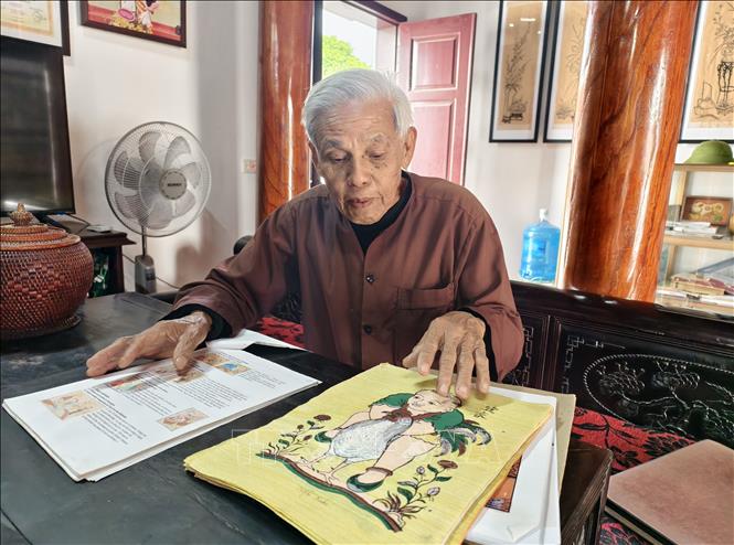 Artisan Nguyen Dang Che introduces hundreds of Dong Ho folk paintings he has collected. VNA Photo: Thanh Thuong