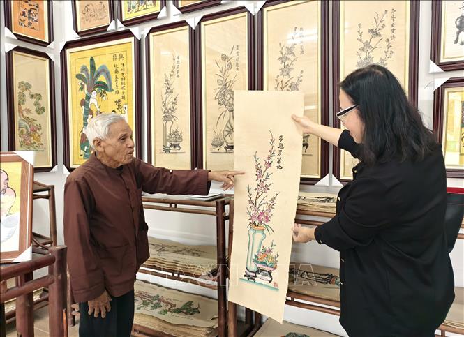 Artisan Nguyen Dang Che introduces Dong Ho folk paintings created by his family. VNA Photo: Thanh Thương