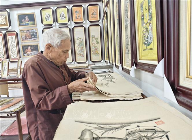 Artisan Nguyen Dang Che organises Dong Ho folk paintings. VNA Photo: Thanh Thương
