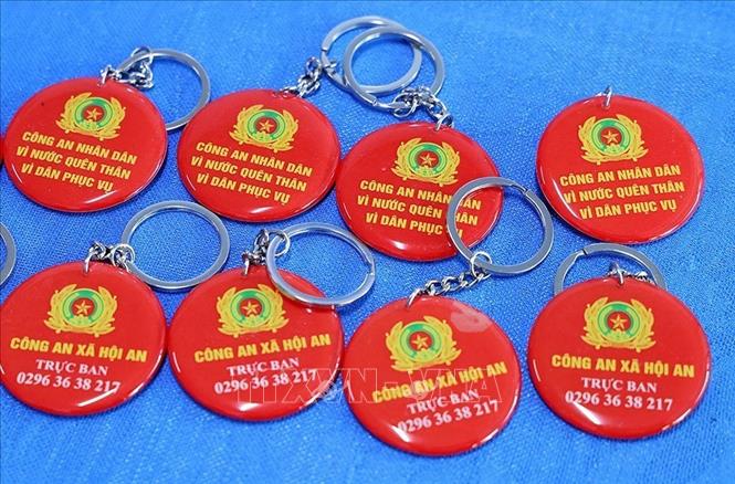 Những chiếc móc chìa khoá nhỏ gọn, có hình ảnh, số điện thoại trực ban Công an xã tiếp nhận thông tin 24/24 giờ, giúp người dân dễ dàng liên hệ khi cần thiết. Ảnh: Công Mạo-TTXVN
