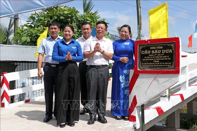 Các đại biểu thực hiện nghi thức gắn biển công trình cầu nông thôn Sáu Dừa. Ảnh: Trung Kiên - TTXVN