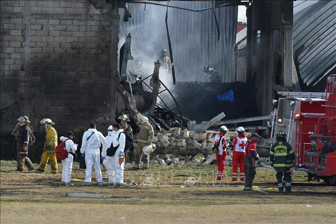Lực lượng chức năng làm nhiệm vụ tại hiện trường vụ rơi máy bay ở bang Estado de México, Mexico ngày 15/12/2025. Ảnh: THX/TTXVN