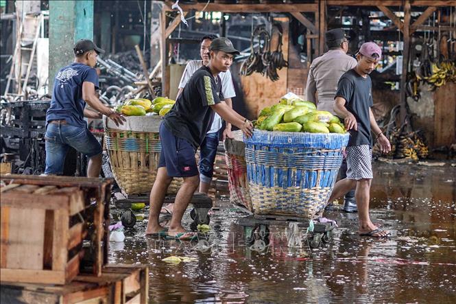 Các tiểu thương chuyển hoa quả ra bên ngoài chợ Kramat Jati ở Jakarta, Indonesia sau vụ hỏa hoạn, ngày 15/12/2025. Ảnh: THX/TTXVN 
