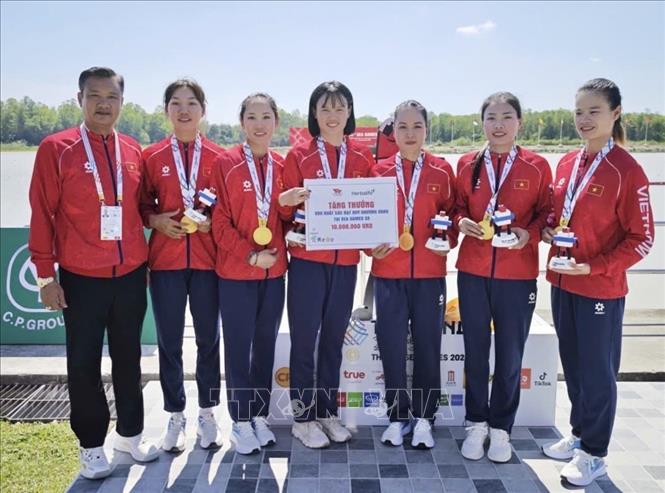 Lãnh đạo đoàn Thể thao Việt Nam trao thưởng, động viên các VĐV Phạm Thị Ngọc Anh, Lê Thị Hiền, Hà Thị Vui, Dư Thị Bông giành HCV Thuyền bốn Nữ một mái chèo. Ảnh: TTXVN phát