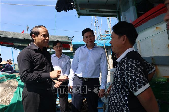 Ông Nguyễn Quốc Đoàn(trái), Ủy viên Trung ương Đảng, Phó Tổng Thanh tra Thường trực Thanh tra Chính phủ thăm hỏi ngư dân trên tàu cá tại cảng cá Tân Phước, xã Long Hải. Ảnh: Hoàng Nhị - TTXVN