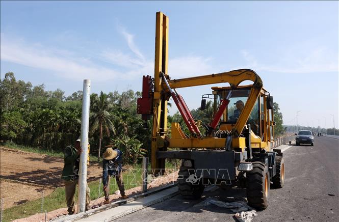 Nhà thầu khẩn trương hoàn thiện lắp đặt hệ thống tôn sóng trên tuyến. Ảnh: Quốc Khánh - TTXVN