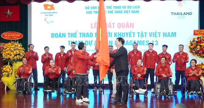 Deputy Prime Minister Mai Van Chinh gives the national flag to the sport delegation. VNA Photo: Trung Tuyến 