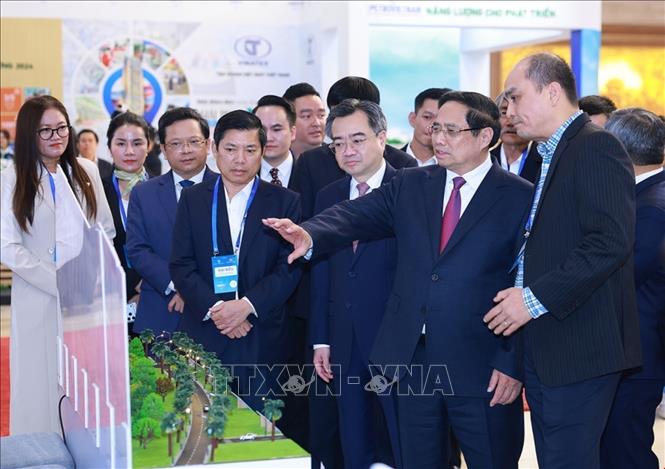 PM Pham Minh Chinh views an exhibition of products within the forum. VNA Photo: Dương Giang