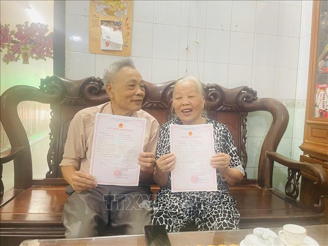 Các cụ cao tuổi nhận giấy kết hôn cấp lại sau thời gian bị thất lạc. Ảnh: Tiến Vĩnh – TTXVN 
