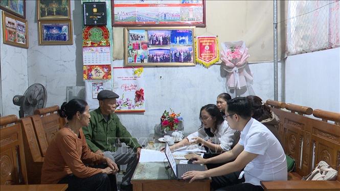 Cán bộ Trung tâm phục vụ hành chính công phường Phù Liễn hỗ trợ người cao tuổi tại nhà. Ảnh: Tiến Vĩnh – TTXVN