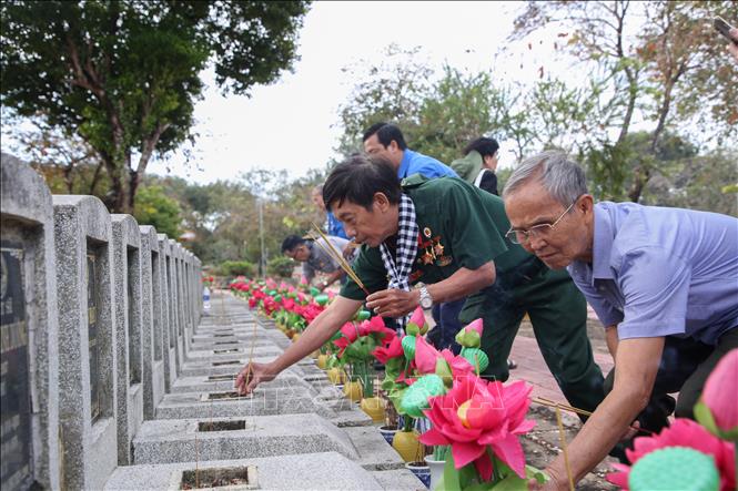 Thắp hương lên các phần mộ liệt sĩ tại Nghĩa trang Liệt sĩ Đồi 82. Ảnh: Giang Phương - TTXVN