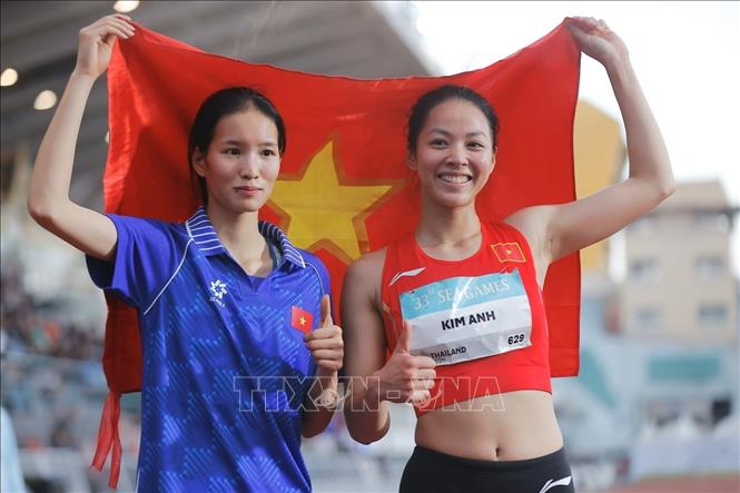 Bùi Kim Anh giương cao lá cờ Tổ quốc sau khi xuất sắc vượt qua mức xà 1,86m tại SEA Games 33. Ảnh: Minh Quyết - PV TTXVN