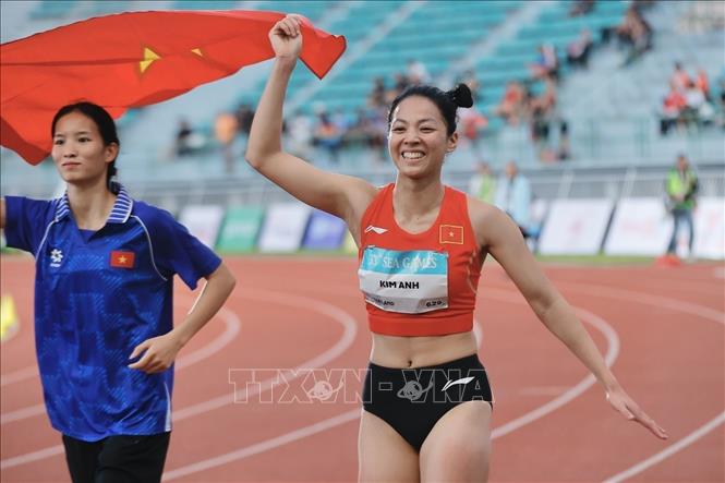 Bùi Kim Anh giương cao lá cờ Tổ quốc sau khi xuất sắc vượt qua mức xà 1,86m tại SEA Games 33. Ảnh: Minh Quyết - PV TTXVN