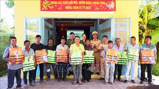Cảnh sát giao thông Công an tỉnh Tây Ninh, tặng áo phao cho người dân và chủ phương tiện hoạt động giao thông thủy trên lưu vực hồ Dầu Tiếng. Ảnh: Minh Phú - TTXVN