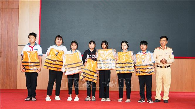 Trung tá Văn Minh Thắng, Phó đội trưởng Đội Cảnh sát giao thông đường thuỷ số 1, Phòng Cảnh sát giao thông Công an tỉnh Tây Ninh, tặng áo phao cho các em học sinh góp phần phòng ngừa tai nạn giao thông đường thuỷ. Ảnh: Minh Phú – TTXVN