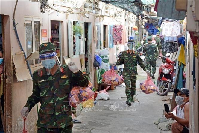 Cán bộ, chiến sỹ Trung đoàn 31, Sư đoàn 309 (Quân đoàn 4) chuyển quà cho nhân dân vùng dịch ở phường 16, quận 8, Thành phố Hồ Chí Minh. Ảnh: Thanh Vũ – TTXVN