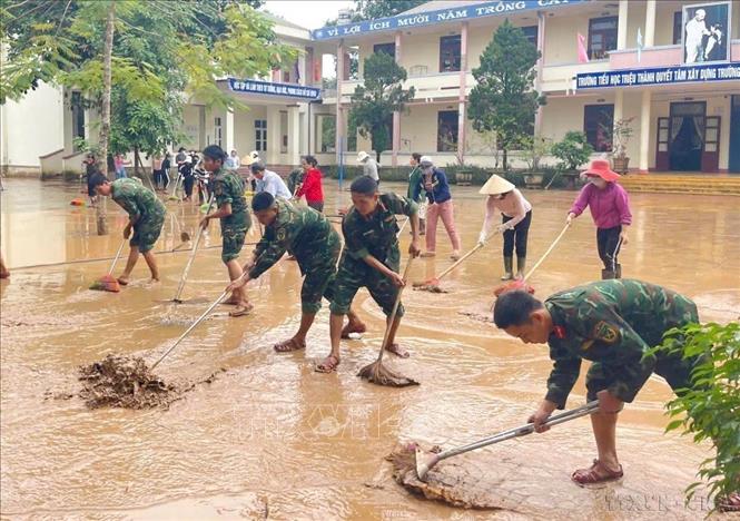 Cán bộ, chiến sĩ Trung đoàn Bộ binh 842 và Ban Chỉ huy Quân sự xã Triệu Phong (Bộ Chỉ huy Quân sự tỉnh Quảng Trị) hỗ trợ trường học và nhân dân khắc phục hậu quả mưa lũ (11/2025).Ảnh: TTXVN phát