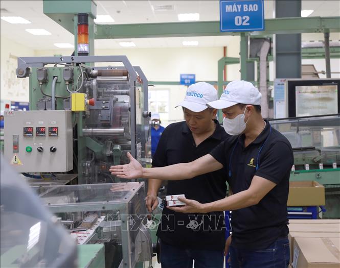 Kỹ sư Nguyễn Duy Khuê hướng dẫn công nhân vận hành máy móc. Ảnh: Xuân Triệu - TTXVN