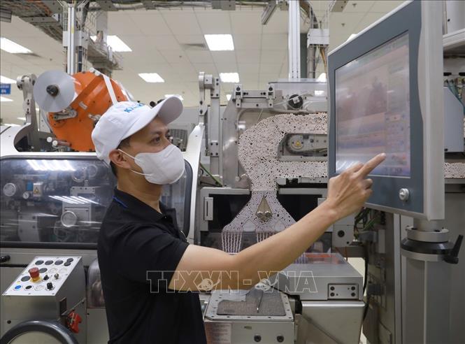 Kỹ sư Nguyễn Duy Khuê vận hành thiết bị tự động hóa. Ảnh: Xuân Triệu - TTXVN