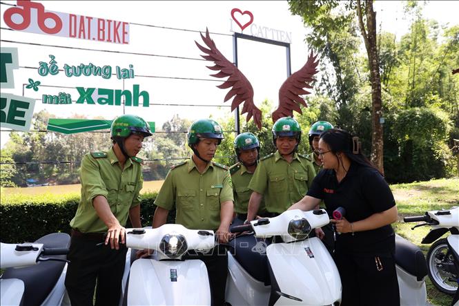 Đại diện nhà tài trợ hướng dẫn cán bộ kiểm lâm cách sử dụng xe máy điện. Ảnh: Hồng Đạt - TTXVN
