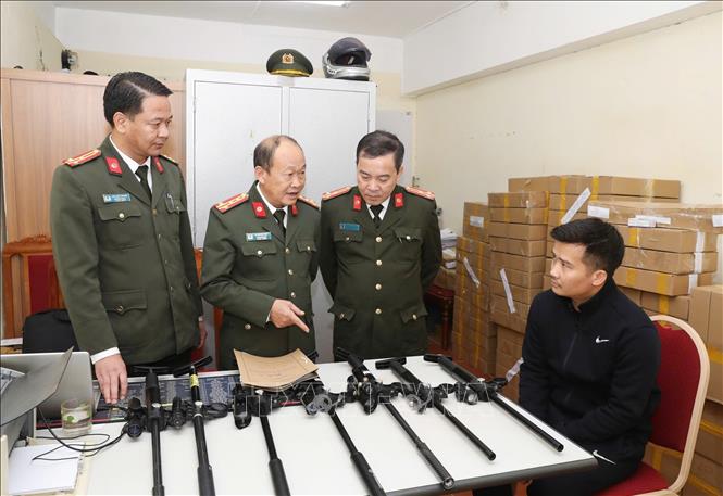 Đối tượng (ngồi) cùng tang vật bị thu giữ. Ảnh: TTXVN phát