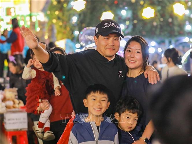 Người dân và du khách lưu lại khoảnh khắc trước Giáng sinh tại Nhà thờ lớn (phường Hoàn Kiếm). Ảnh: Khánh Hoà - TTXVN