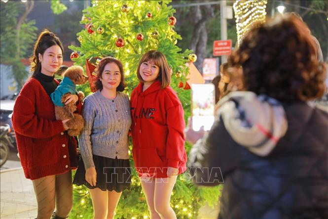 Người dân và du khách lưu lại khoảnh khắc trước Giáng sinh. Ảnh: Khánh Hoà - TTXVN