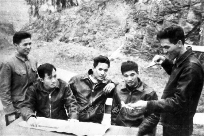 Phi công Phạm Tuân (ngoài cùng bên phải) cùng đồng đội thảo luận đánh B-52 trong trận 12 ngày đêm, tháng 12/1972. Ông là người đầu tiên lái máy bay Mig-21FM bắn rơi tại chỗ “siêu pháo đài bay” B-52 trong lần xuất kích đêm 27/12/1972. Ảnh: TTXVN 