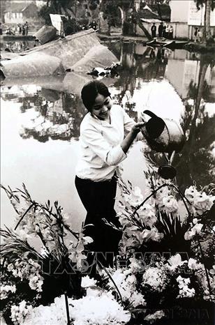 Hình ảnh cô gái tưới hoa bên xác chiếc máy bay Mỹ B-52 rơi ở hồ Hữu Tiệp, làng Ngọc Hà (Hà Nội) tô điểm thêm cho chiến thắng của quân và dân Hà Nội trong chiến thắng lịch sử 