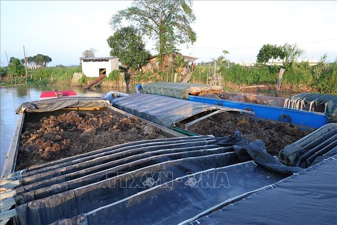 Sà lan chở số lượng lớn đất không có hoá đơn chứng từ bị lực lượng chức năng phát hiện, bắt giữ. Ảnh: TTXVN phát