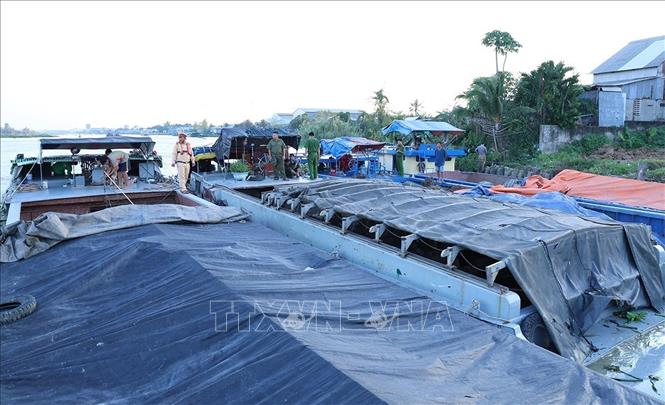 Sà lan chở số lượng lớn đất trái phép bị lực lượng chức năng phát hiện, bắt giữ. Ảnh: TTXVN phát